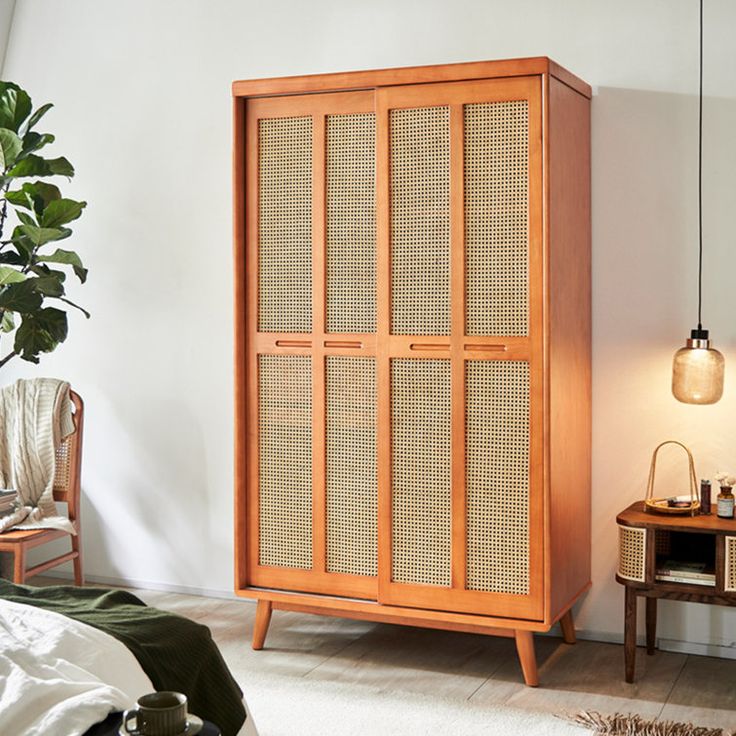 a wooden cabinet with wicker doors in a bedroom