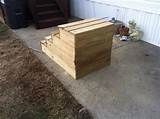 a wooden box sitting in the middle of a yard next to a trash can and stairs