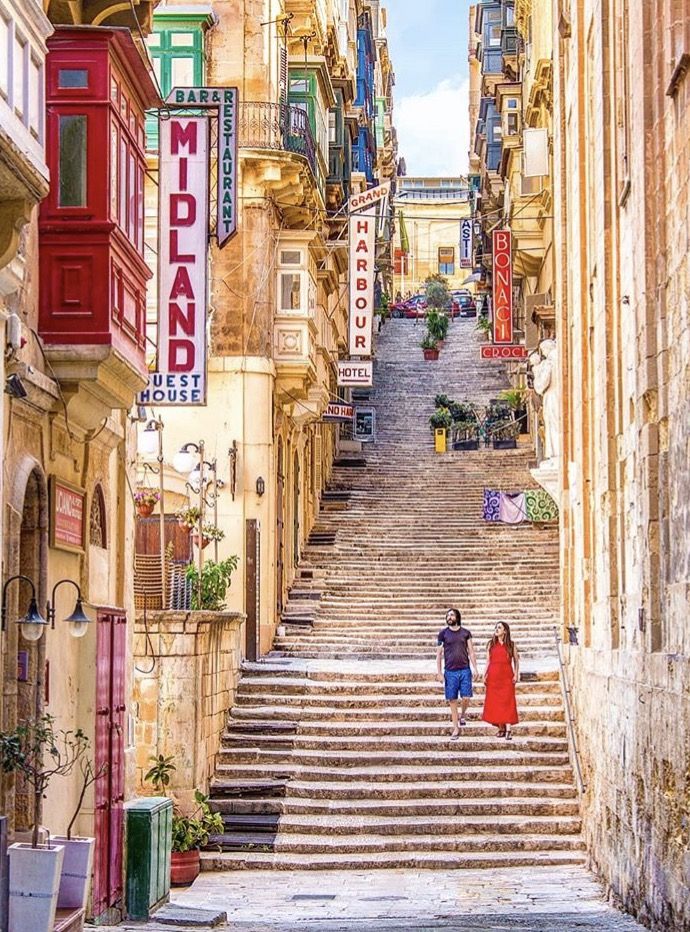 two people are walking down some stairs in the city