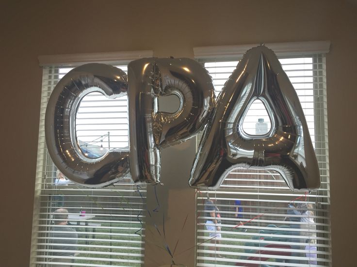 the balloons are in the shape of the letters q and person on the window sill