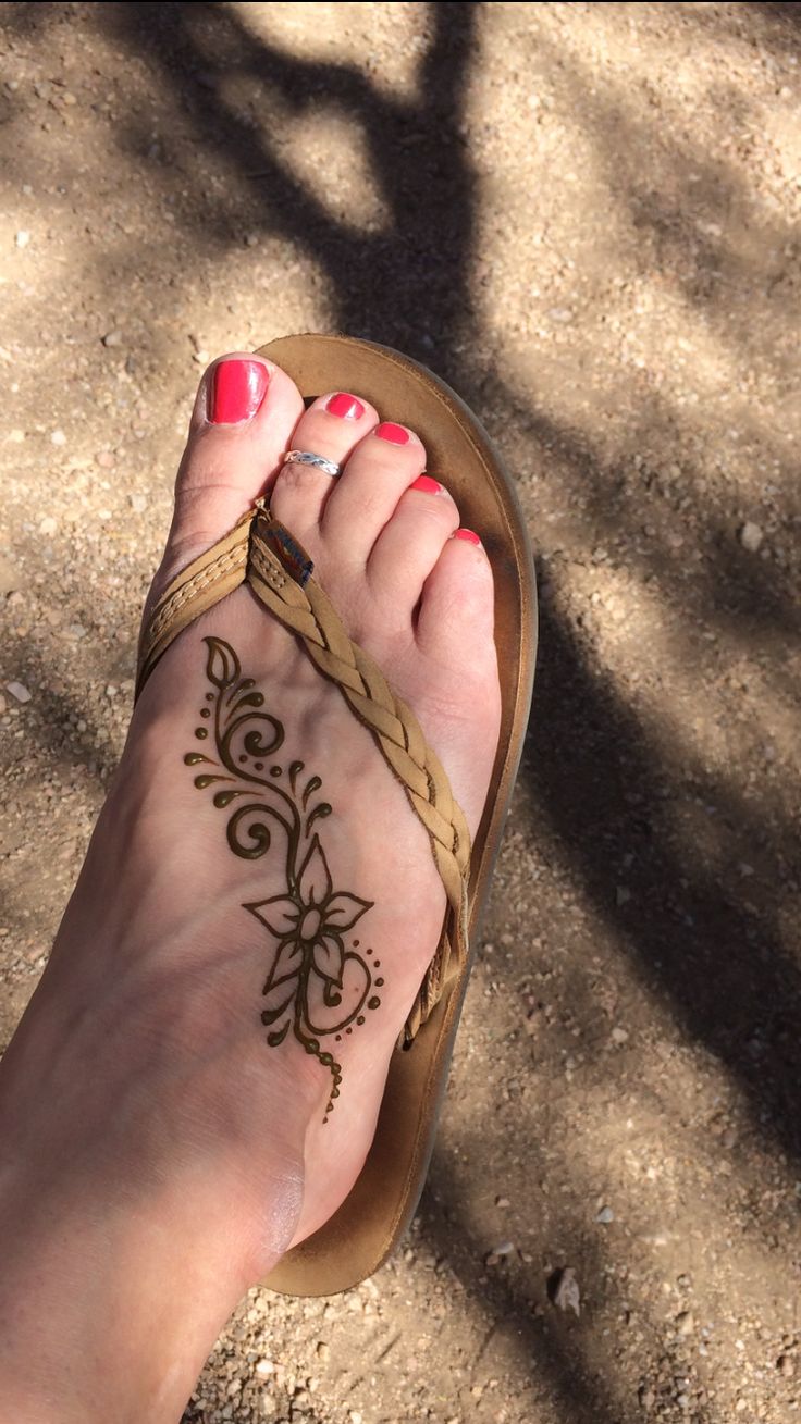 a woman's foot with henna on it