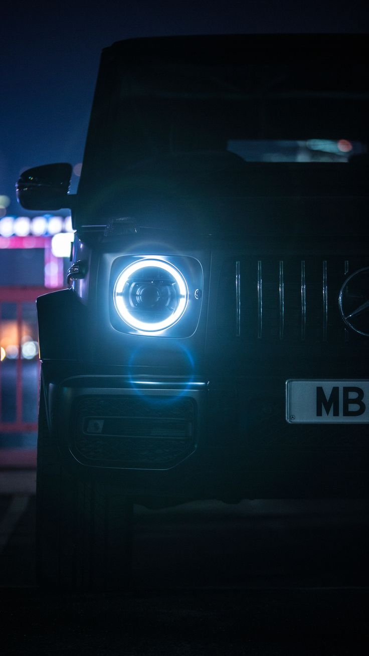 the front end of a car with its lights on