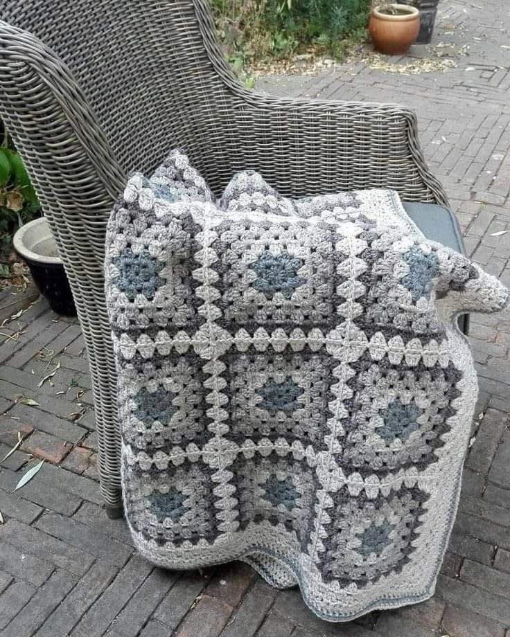 a crocheted blanket sitting on top of a chair