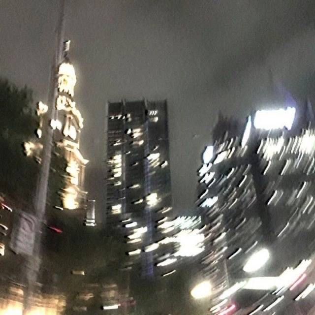 a blurry photo of some buildings in the city at night with street lights and traffic