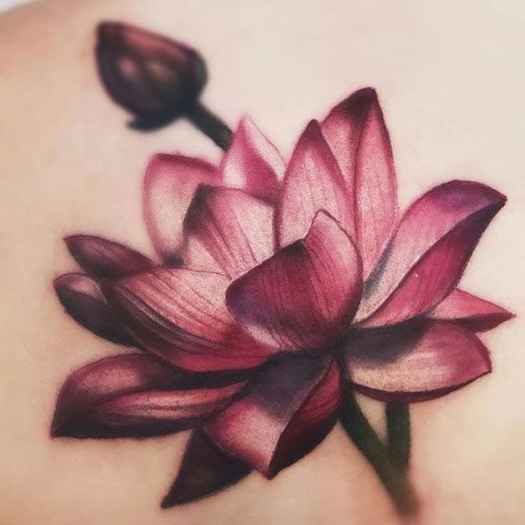 a woman's back with a flower tattoo on it