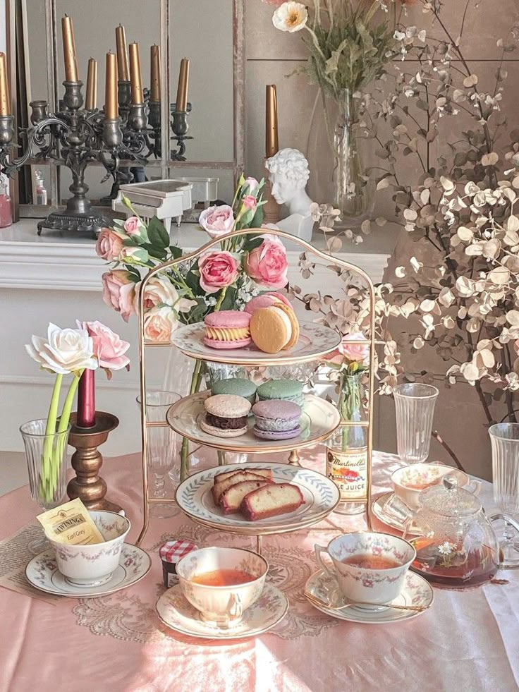 a table topped with plates and cups filled with food next to a vase full of flowers