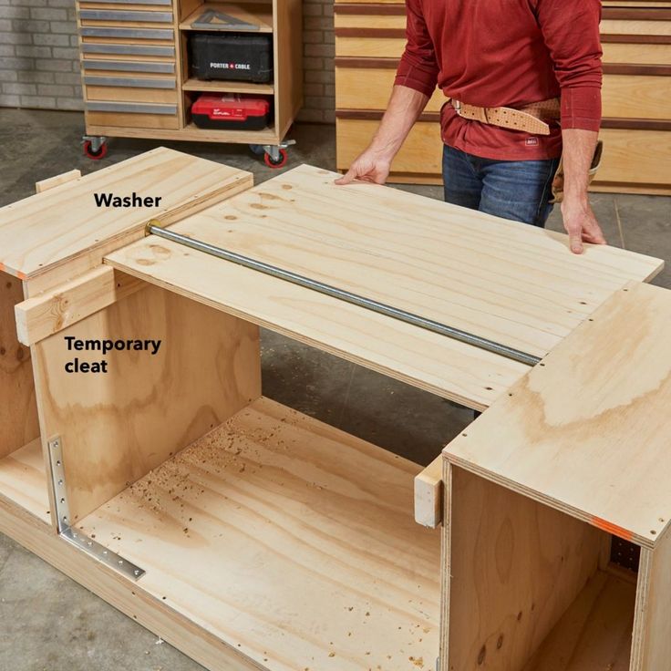 a man standing in front of a workbench holding a piece of wood with the words washer and temporary cleat on it