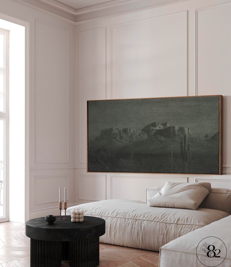 a living room filled with furniture and a painting on the wall