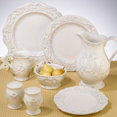 a table topped with white dishes and cups