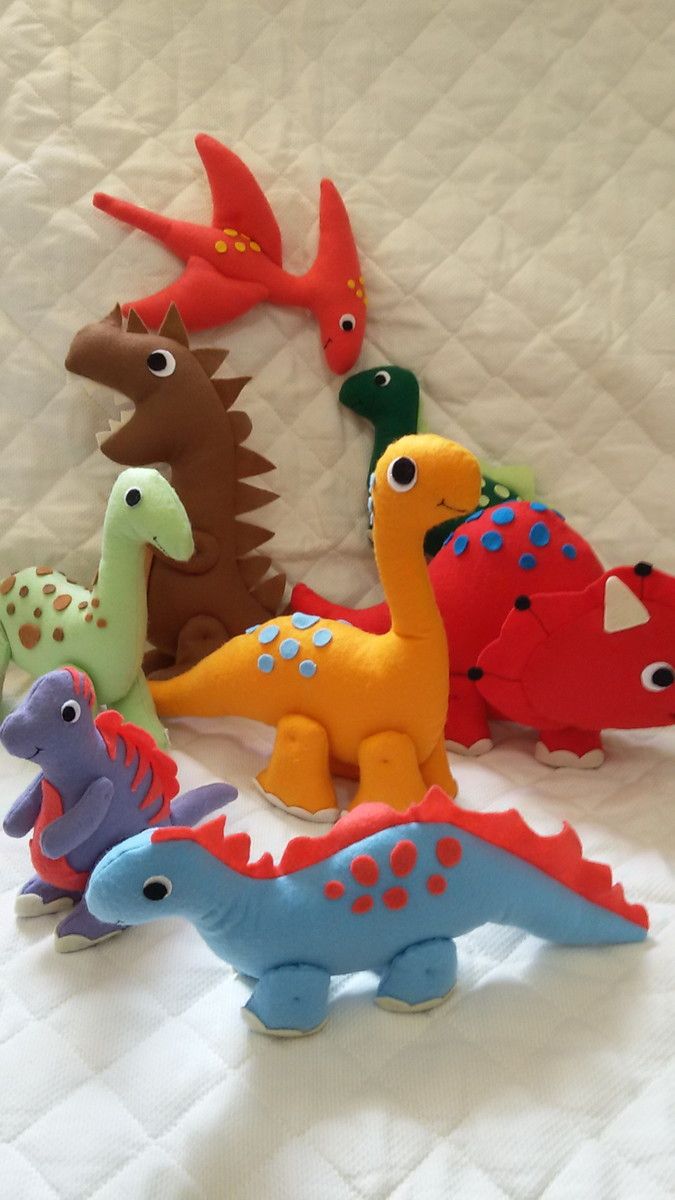 a group of toy dinosaurs sitting on top of a bed