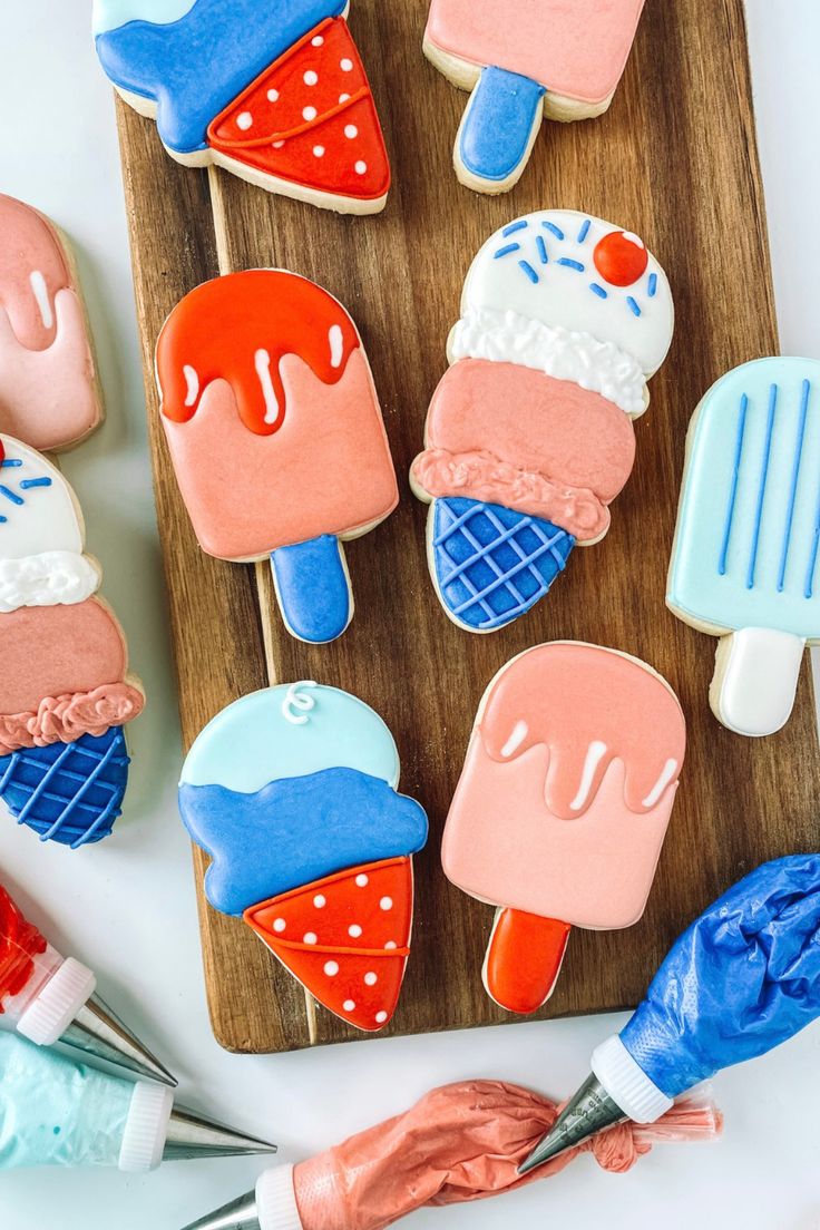 decorated ice cream and popsicle cookies on a cutting board