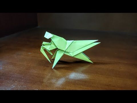 an origami bird sitting on top of a wooden table