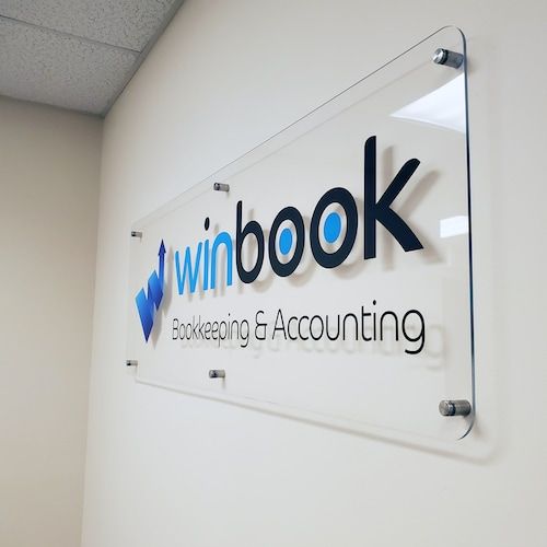 a glass sign hanging on the side of a wall that says winbook banking and accounting