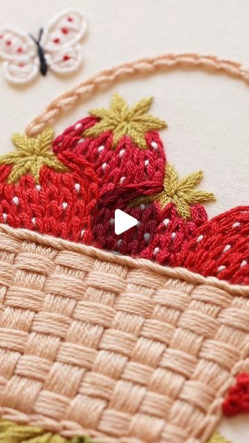 a close up of a basket with strawberries on it and a butterfly in the background