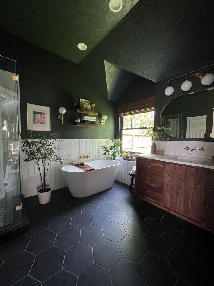 a bathroom with black tile flooring and white bathtub next to a large window