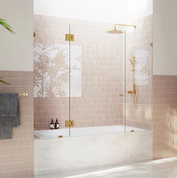 a bathroom with pink tiles and gold fixtures