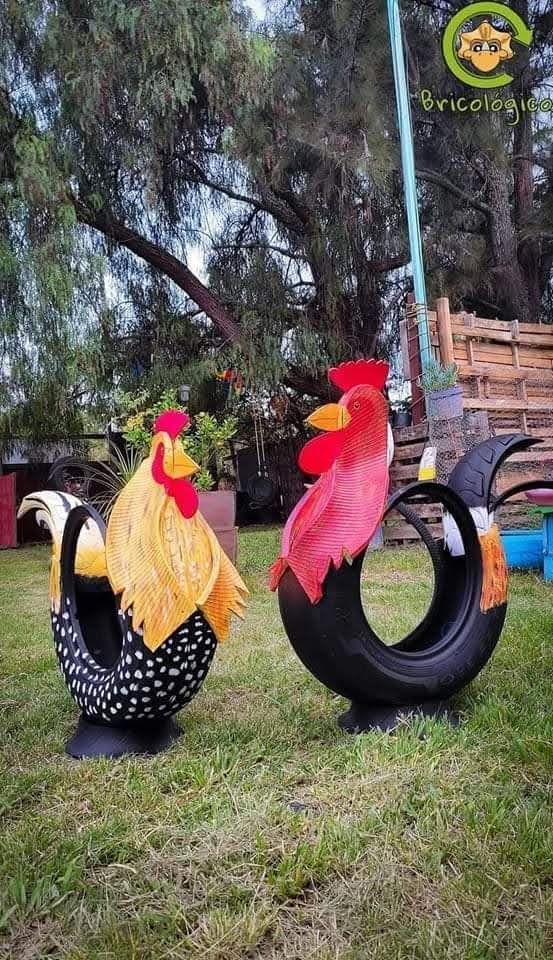 two roosters made out of tires sitting in the grass