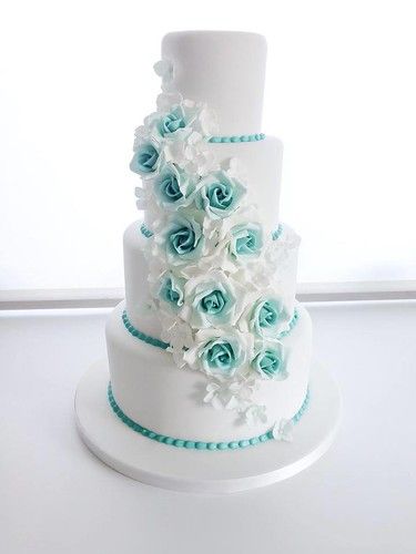 a three tiered white and blue wedding cake