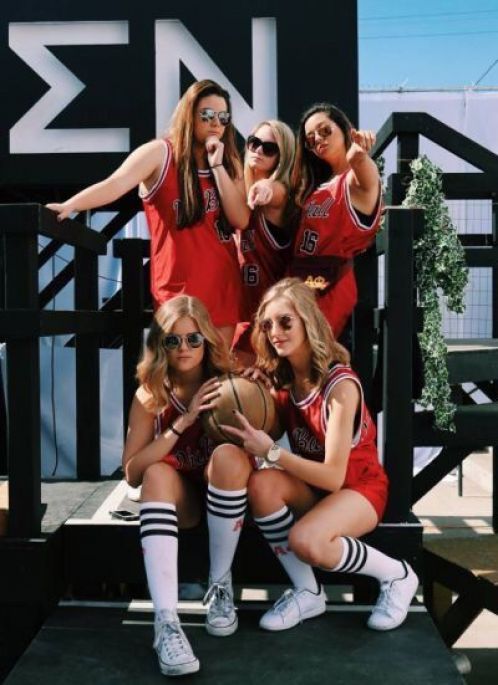 a group of women in red uniforms posing for a photo with basketballs on their feet