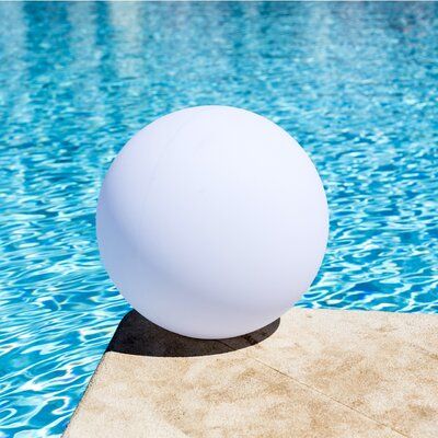 a large white ball sitting on top of a pool