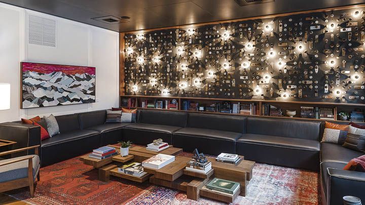 a living room filled with furniture and lots of lights on the wall above it's bookshelf