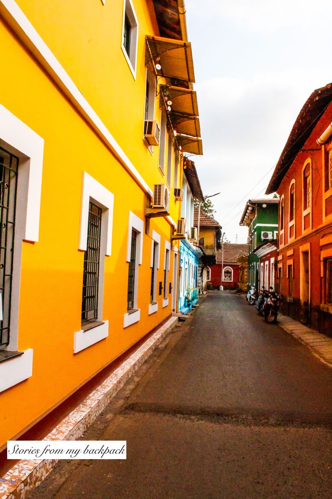 an empty street with buildings painted yellow and red