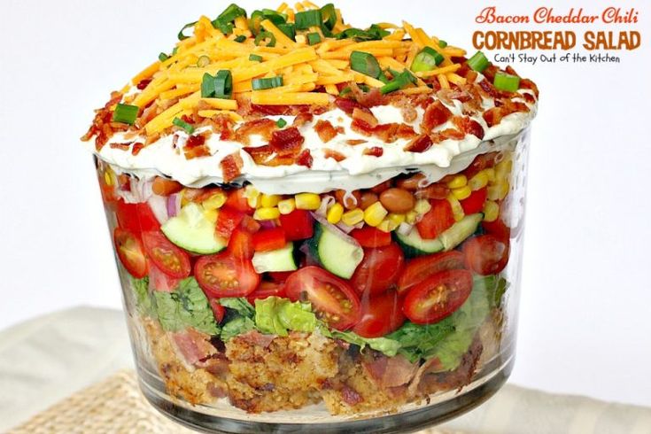 a layered salad in a glass dish on a table