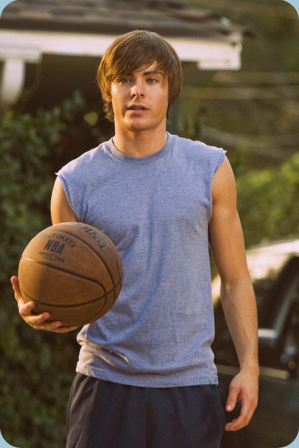 a young man holding a basketball in his hand