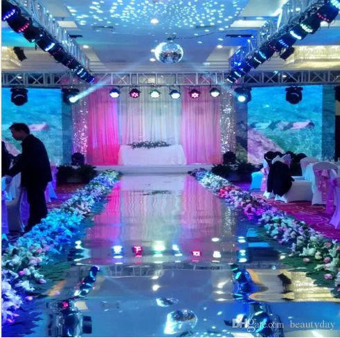 an indoor wedding setup with white and pink flowers on the floor, blue lights in the background