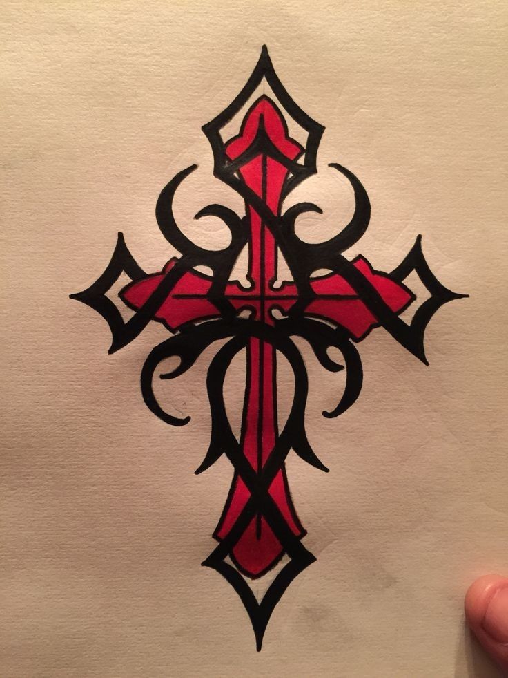 a hand holding up a cross drawn in black and red ink on white paper,