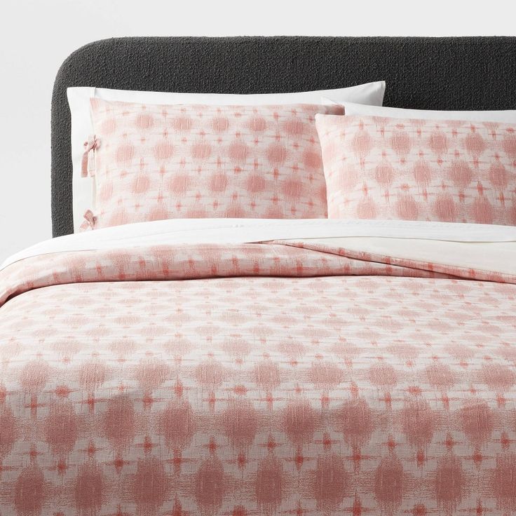 a bed covered in pink and white sheets