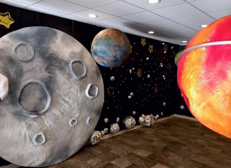 two large planets are in the middle of a room with stars and other objects around them