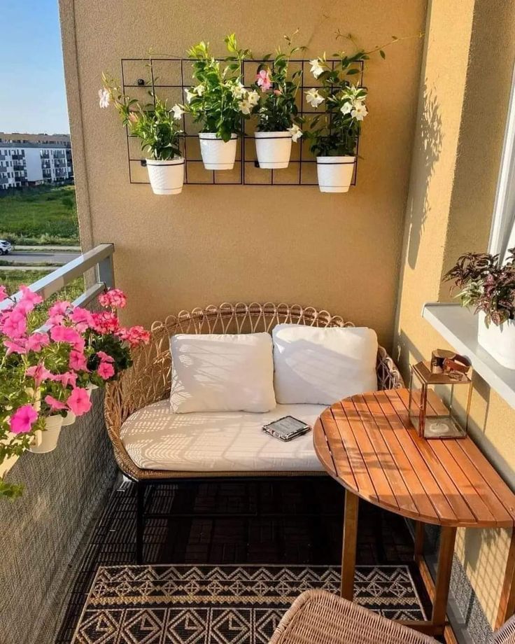 a balcony with potted plants on the wall and a couch in the corner next to it