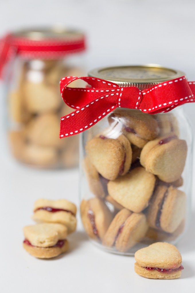 small cookies in a jar with a red ribbon