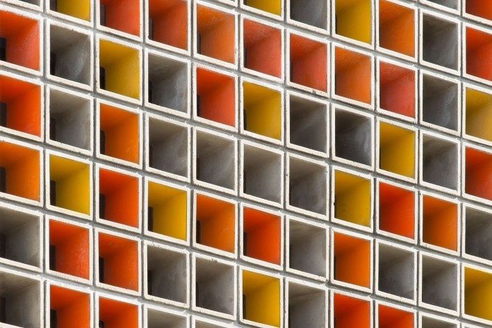 an orange and yellow tiled wall in front of a building