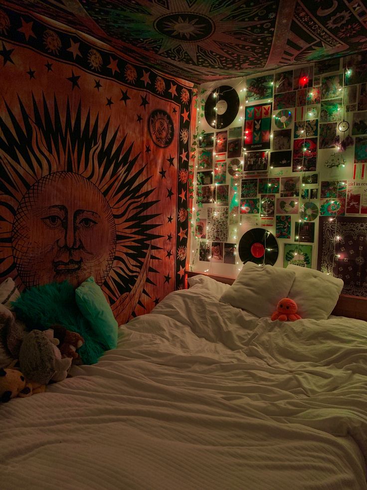 a bed with white sheets and lights in a room that has a tapestry on the wall