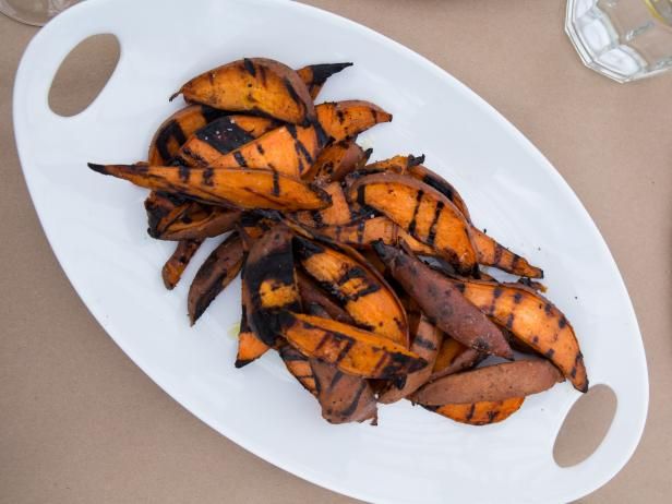 a white plate topped with grilled bananas on top of a table