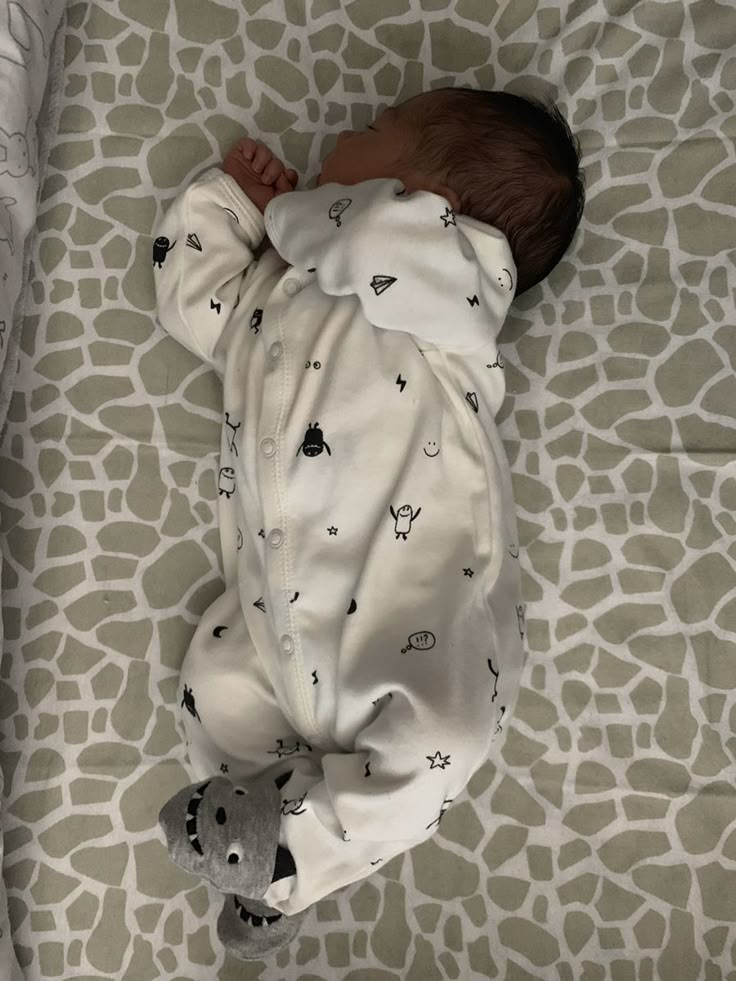 a baby is sleeping on a giraffe print blanket