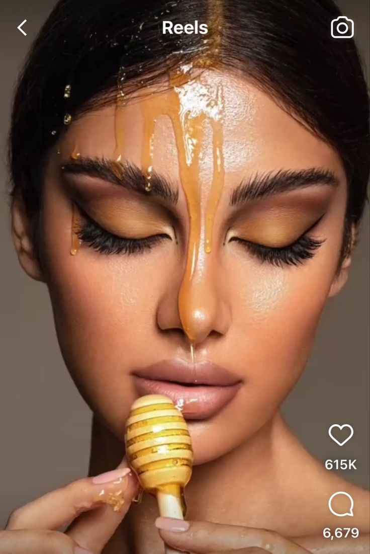 a woman with honey on her face holding a brush