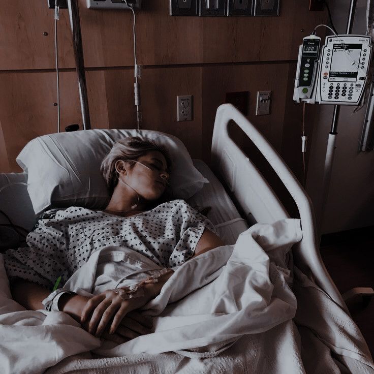 a woman laying in a hospital bed next to an iv machine