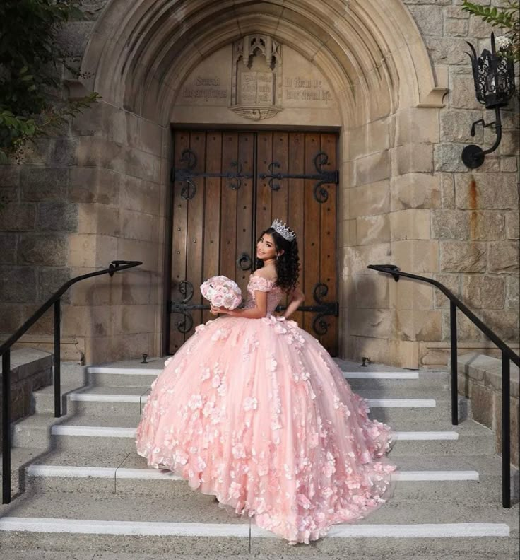 a woman in a pink dress is sitting on some steps