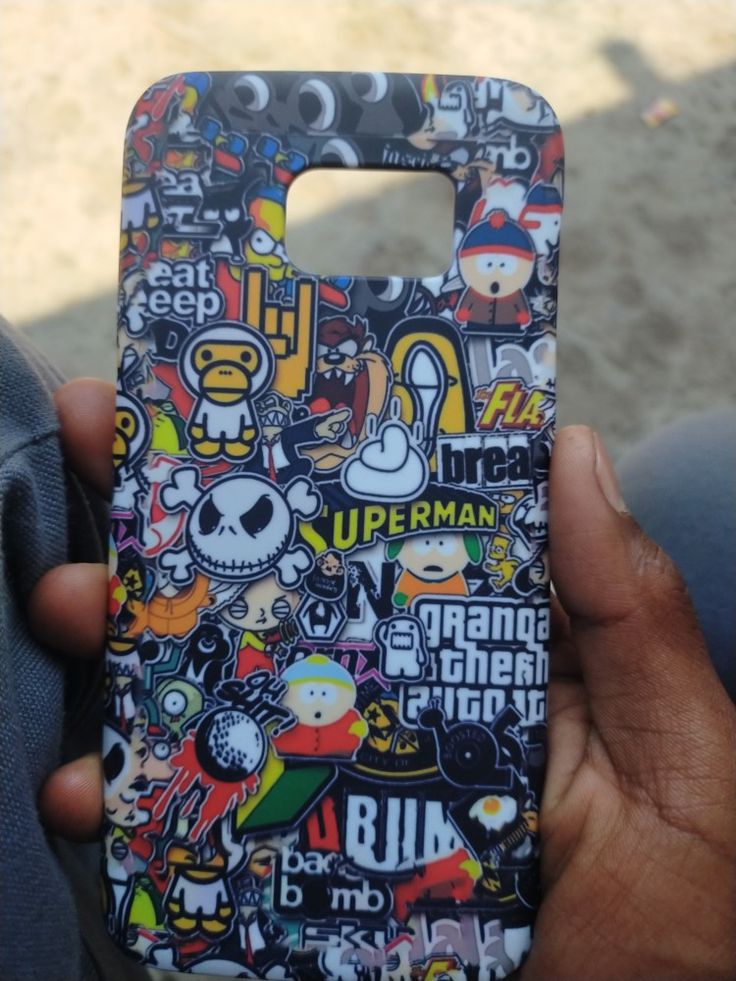 a person holding up a cell phone case with stickers all over the front and back