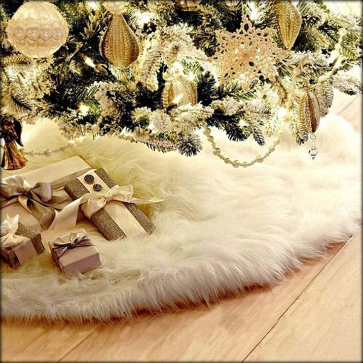 a christmas tree with presents under it in front of a white and gold decorated tree