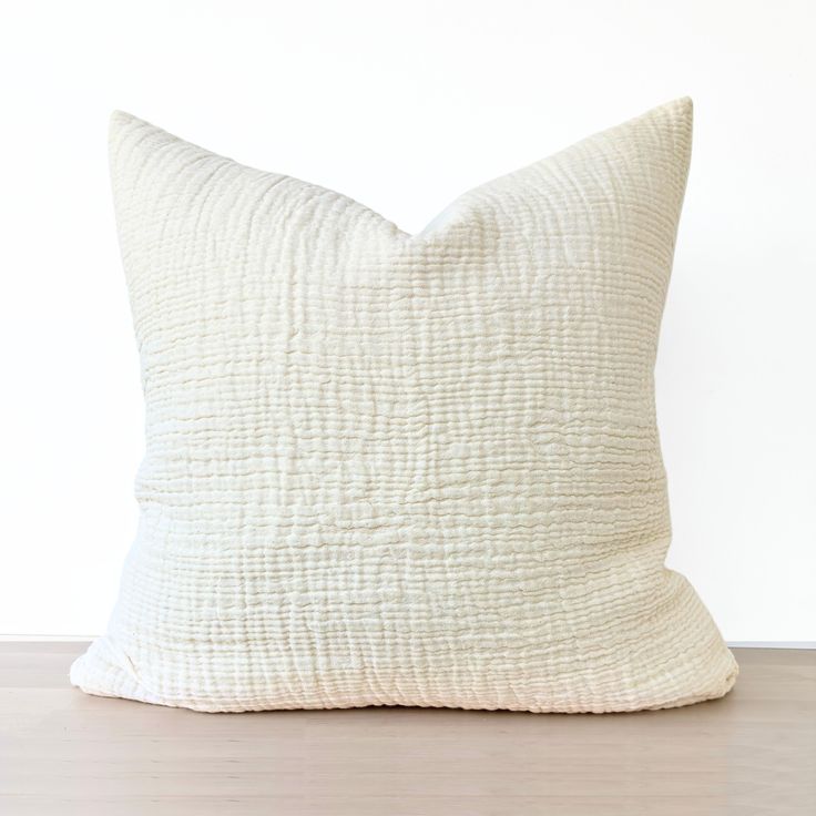 a white pillow sitting on top of a wooden floor