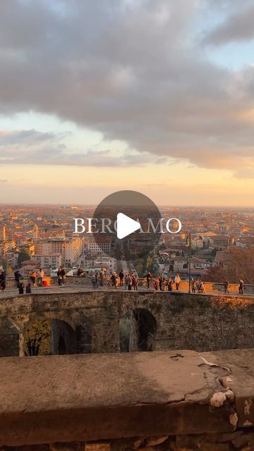 the view from the top of an old building with people walking on it and buildings in the background