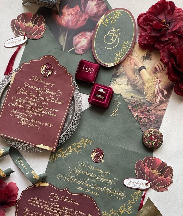 the wedding stationery is laid out on top of each other, with red flowers