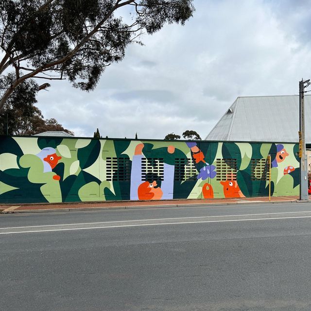 a large mural on the side of a building with flowers painted on it's sides