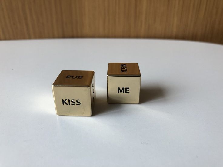 two cubes with the words kiss me written on them sitting on a table next to each other