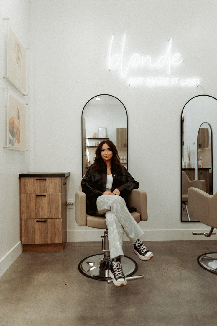 a woman sitting in a chair with her feet up on the hair table and looking at the camera