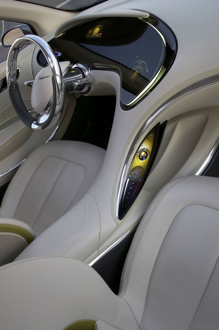 the interior of a car with white leather and chrome trims, steering wheel and center console